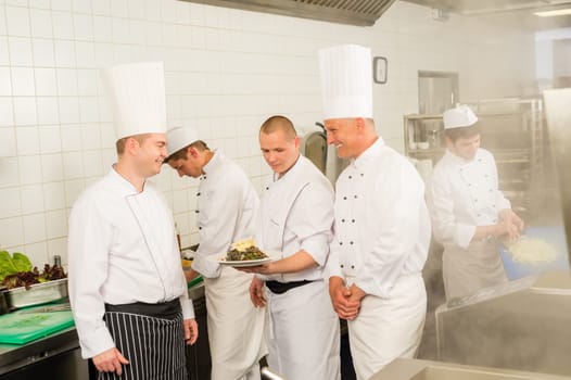Professional kitchen busy team cooks and chef prepare meal