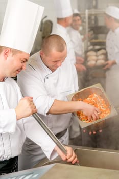 Professional chef cook with team prepare food in industrial kitchen