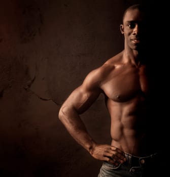 Beautiful and muscular black man in dark background