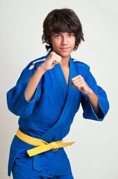 Young fighter posing against a light background
