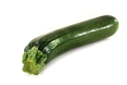 a green zucchini against a white background
