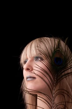 Young woman with peacock feather