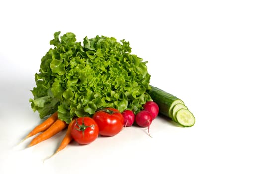 Fresh salad and vegetables against white background