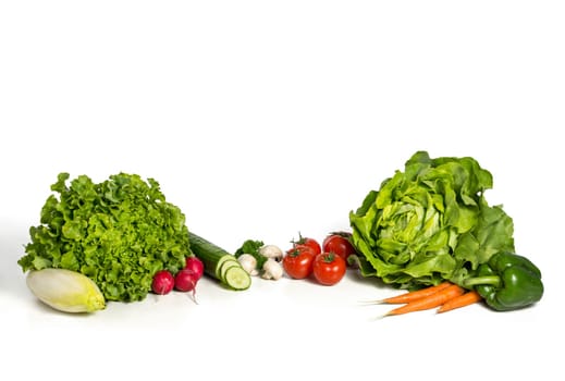 Fresh salad and vegetables against white background