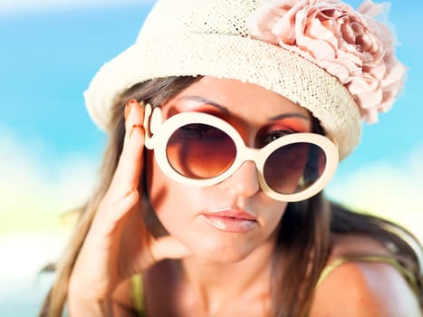 Beautiful woman in sunglasses and hat outdoor