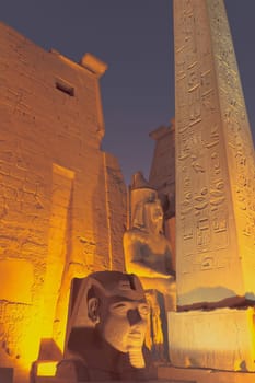 The obelisk and statue of the King Ramses II. at the entrance to Luxor Temple (Egypt)