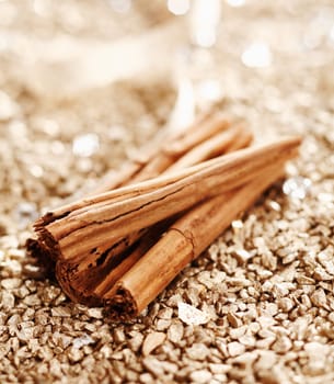 Some Cinnamon Sticks on a shiny golden background for wintery food concepts