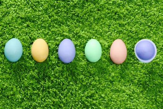 colored easter eggs in a row son green background