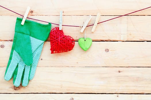 Gardening Love. The beautyful feeling of yard work. Some hearts and gardening hand gloves on a wooden background