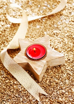 Christmas Candle with a golden bow on a festive background