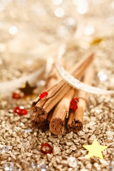 Cinnamon Sticks with a ribbon on a golden background for Christmas Concept.