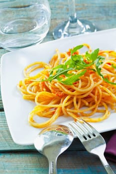 Plate of delicious pasta topped with fresh herbs served ready for dining.