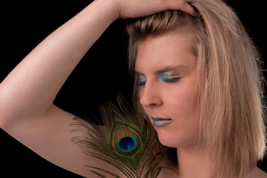 Young woman with peacock feather