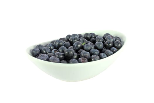 Fresh blueberries in a white bowl, isolated on white
