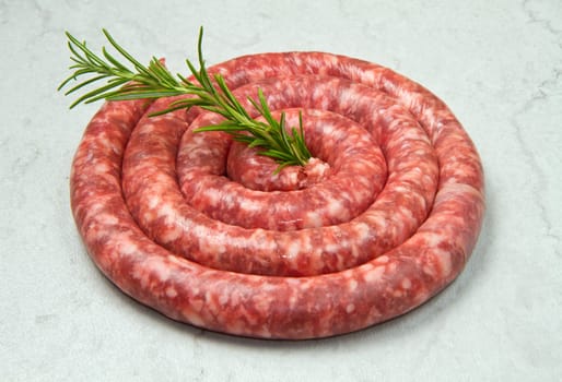 fresh raw sausage with rosemary on marble  background