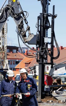building workers with large heavy machinery in background
