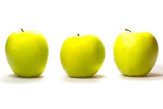 Three yellow-green apples in a row isolated on white background.