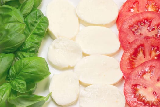 Mozzarella, tomatoes and basil leaves that make up the Italian flag.