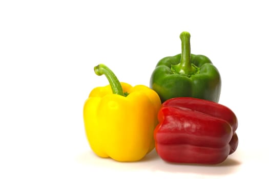 Green, red and yellow paprika (pepper) isolated on a white background. Horizontally.
