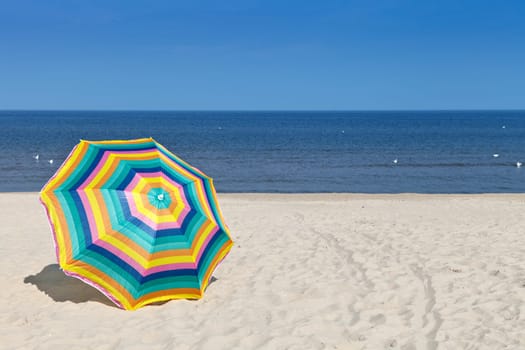 Umbrella on a sandy beach, summer time