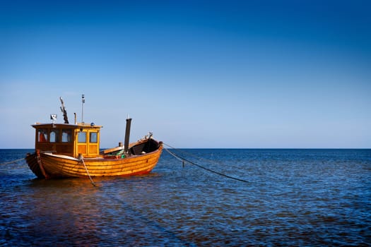 Fishing boat floating on the water, blue sea and sky with copyspace