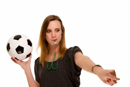 Woman with soccer ball and whistle pointing at something against white background