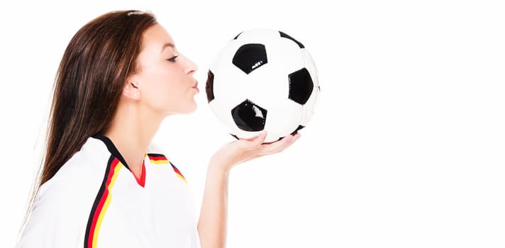 Beautiful young woman kissing soccer ball against white background