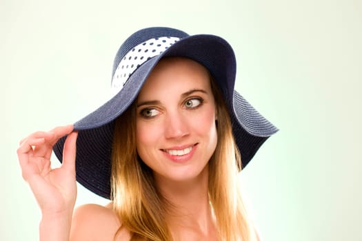 Portrait of a woman with a summer hat against a light green background