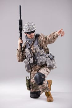Armed Soldier in camouflage pointing with a finger