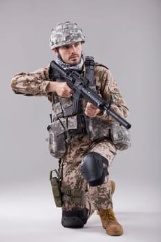 Kneeling Soldier with machine gun in studio