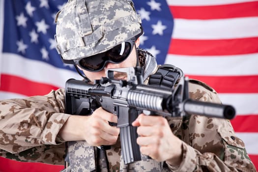 American soldier shooting or aiming - american flag waving in background