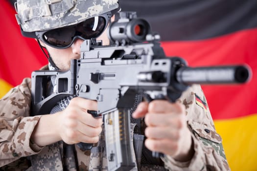 soldier with machine gun aiming over german flag