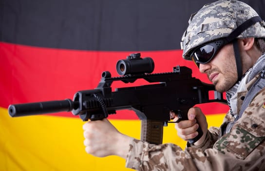 German soldier with machine gun aiming or shooting - german flag in background