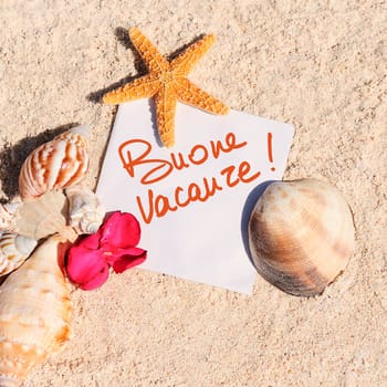 blank paper on white sand beach with starfish and shells like summer vacation background
