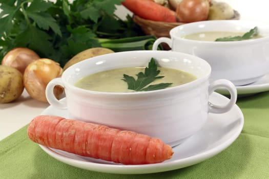 two cups of vegetable cream soup with parsley