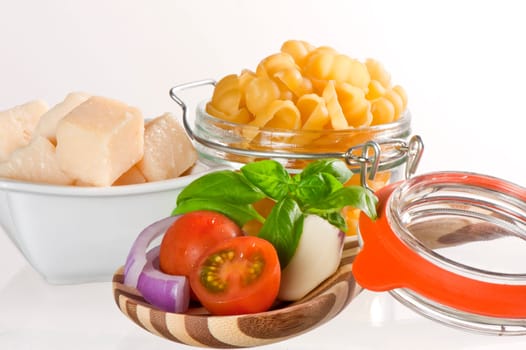 Italian pasta and ingredients for dressing on a white background