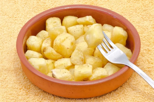 Fried pieces of potatoes with oil , dill pepper and salt. plate with typical spanish patatas bravas.