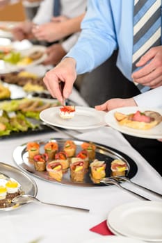 Catering at business company event people choosing buffet food appetizers