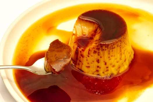 Delicious vanilla cream, egg custard with caramel sauce, and spoon