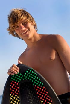 Handsome surfer posing in the beach