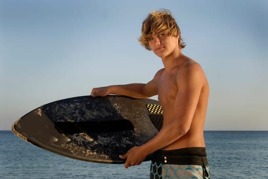 Handsome surfer posing in the beach