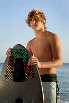 Handsome surfer posing in the beach