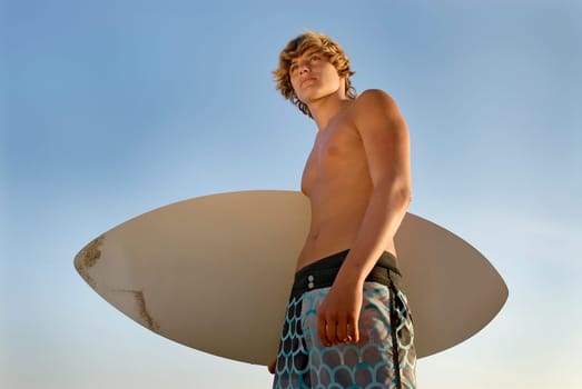 Handsome surfer posing in the beach