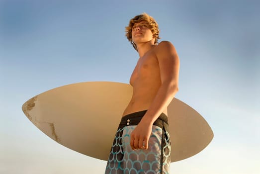 Handsome surfer posing in the beach