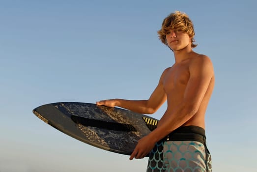 Handsome surfer posing in the beach