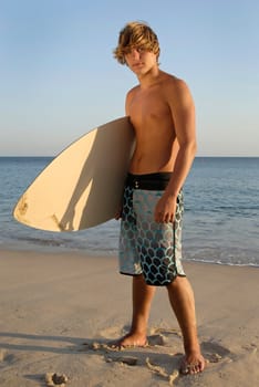 Handsome surfer posing in the beach