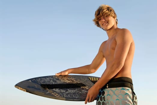 Handsome surfer posing in the beach
