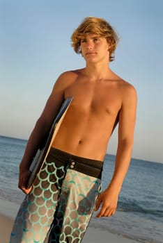 Handsome surfer posing in the beach