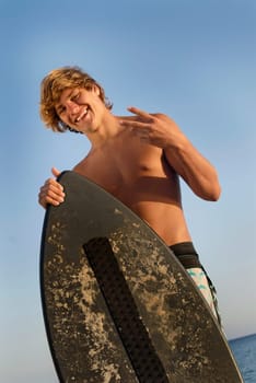 Handsome surfer posing in the beach