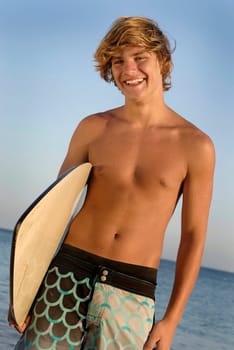 Handsome surfer posing in the beach